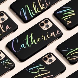 Puede incluir: Fundas de teléfono negras con nombres personalizados en escritura de gradiente arcoíris. Las fundas presentan un diseño elegante y están personalizadas con nombres como "Catherine" y "Nikki".