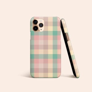 May include: A phone case with a plaid pattern in shades of pink, yellow, green, and beige. The case has a cutout for the camera lens.