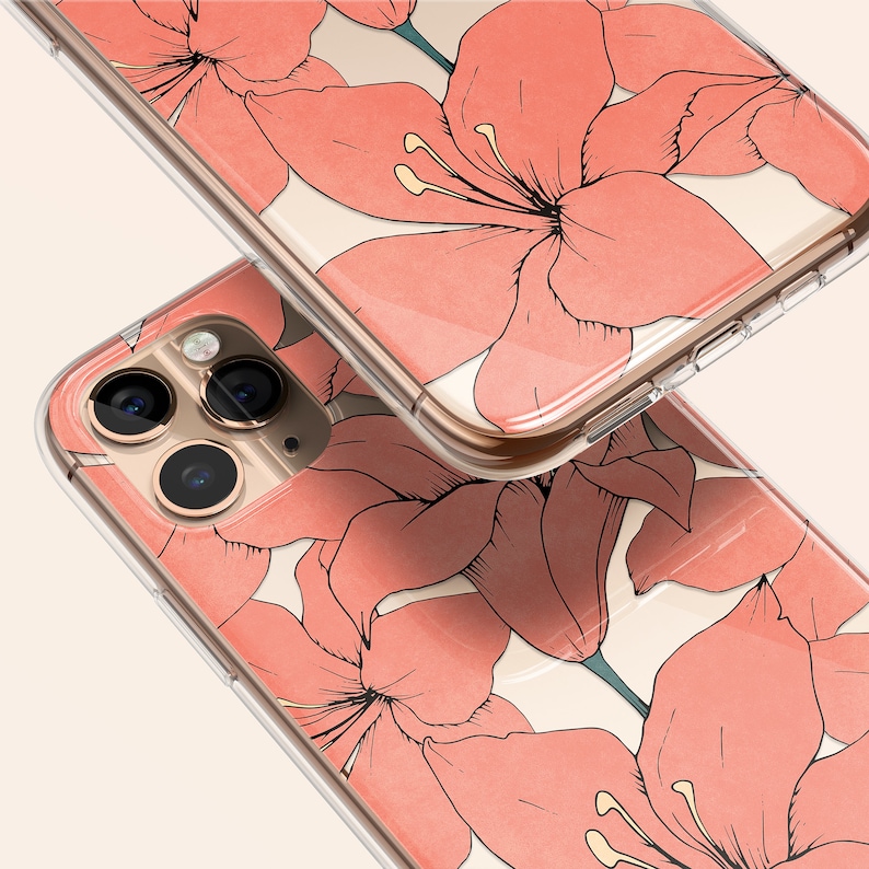 Puede incluir: Una funda transparente para tel&eacute;fono con un dise&ntilde;o floral. La funda presenta flores rosas sobre un fondo blanco. La funda est&aacute; dise&ntilde;ada para un iPhone con una c&aacute;mara de triple lente.