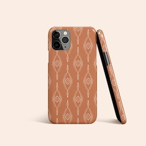 May include: A brown phone case with a white geometric pattern. The case has a cutout for the camera lens.
