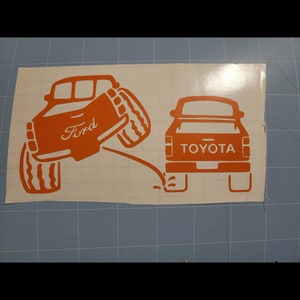 Ford truck peeing on Toyota truck