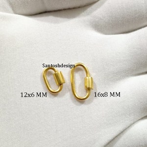 Pode incluir: Dois fechos de lagosta de metal dourado, um medindo 12x6 mm e o outro 16x8 mm. Santoshdesign está impresso na superfície branca.