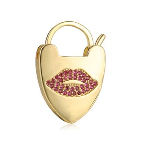 May include: Gold heart-shaped padlock charm with a pink rhinestone lip design.