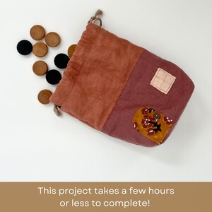 May include: A red and pink fabric drawstring bag with a floral pattern and a button. The bag is filled with wooden game pieces.