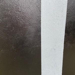 May include: A close-up of a textured surface painted in black and white stripes.