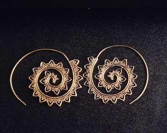May include: A pair of gold-toned hoop earrings featuring a spiral design. Each earring is constructed from a thin wire that coils outward, decorated with a series of small, heart-shaped cutouts along the outer edge of the spiral pattern.