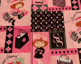 Könnte beinhalten: Rosa Stoff mit einem sich wiederholenden Muster, das ein Cartoon-Mädchen mit roten Haaren zeigt, das ein rosa Outfit trägt und Einkaufstaschen trägt. Die Worte "Sweet Shopping!" sind ebenfalls vorhanden.