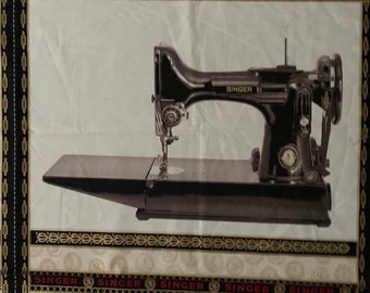 May include: A black Singer sewing machine is centered on a white fabric with decorative borders. The machine has a silver needle and a black base. The fabric has a repeating pattern of coins and the word "SINGER" in red.