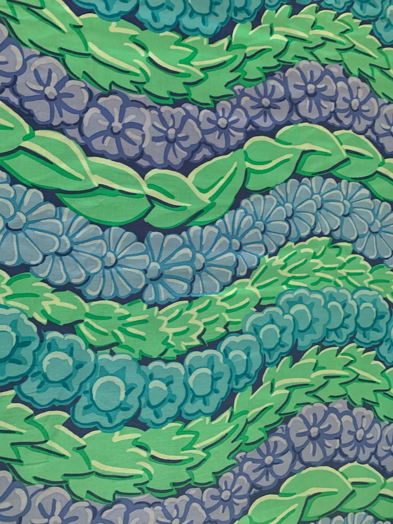 Op de afbeelding: Een herhalend patroon van gestileerde bloemen en bladeren in tinten blauw, groen en wit op een donkerblauwe achtergrond. Het ontwerp toont rijen bloemen en bladeren, waardoor een getextureerd, gelaagd effect ontstaat. Geschikt voor stof of behang.