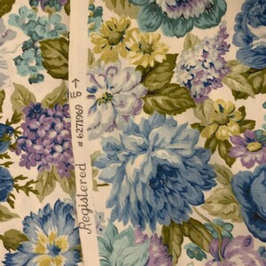 May include: Floral fabric with a pattern of large blue, purple, and yellow flowers on a white background. The fabric has a Registered label with the number 6271969.