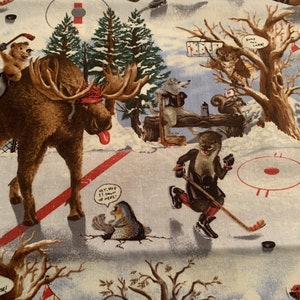 May include: A whimsical illustration of a moose, otter, and other woodland creatures playing hockey on a snowy field. The moose is wearing a red hat and has a long tongue sticking out. The otter is wearing a hockey uniform and holding a hockey stick. The background features trees, snow, and a red and white hockey net.