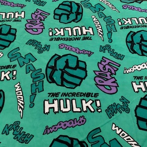 May include: Green and white fabric with a repeating pattern of the Incredible Hulk's fist, the words "The Incredible Hulk!" and sound effects like "Smash!" and "Wooosh!"