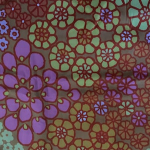 May include: A textile featuring a repeating floral pattern in shades of brown, pink, orange, green, and purple. The design includes various flower shapes, such as stylized blossoms and petal clusters, creating a vibrant and colourful textile.