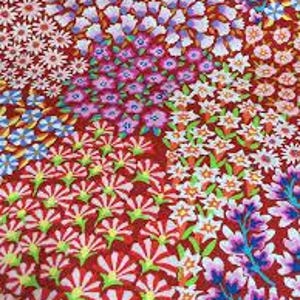 May include: A vibrant red fabric featuring a dense, repeating pattern of stylised flowers in shades of pink, purple, light blue, white, and yellow. The floral design includes various petal shapes and sizes arranged in a continuous, colourful botanical print.