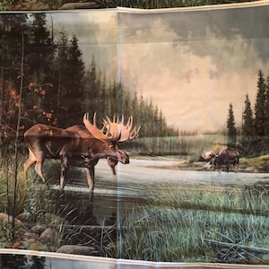 May include: A fabric panel depicting a painting of two moose in a river setting. The moose, with large antlers, are set against a backdrop of trees and water. The artwork evokes a natural, outdoor theme.