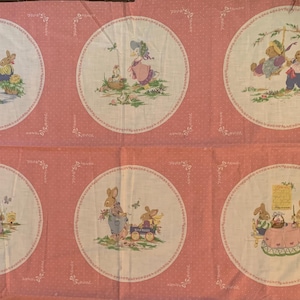 Peut inclure: Tissu rose avec six illustrations circulaires de lapins dans diverses scènes, comme jouer sur une balançoire et pique-niquer. Le tissu présente un motif à pois et des bordures décoratives avec des motifs floraux et fruitiers.