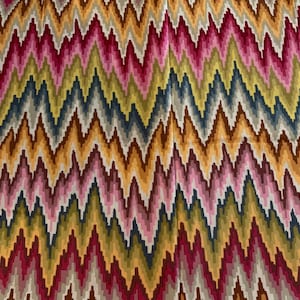 May include: A colorful fabric with a chevron pattern in shades of pink, red, yellow, orange, brown, and blue.