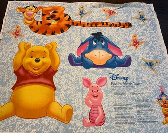 May include: A light blue fabric panel with a white mottled pattern featuring Disney characters Tigger, Winnie the Pooh, Eeyore, and Piglet. The fabric includes colorful butterflies and printed text reading Disney Pooh-n-Friends Totem with sewing instructions.
