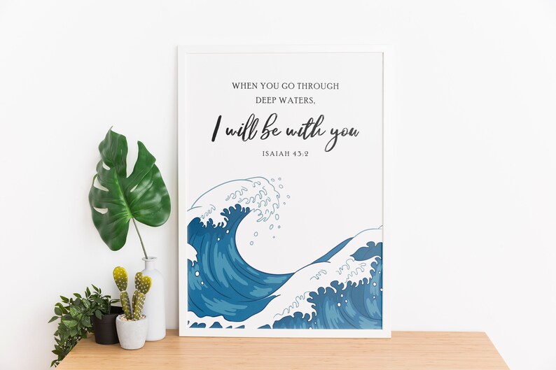 K&ouml;nnte beinhalten: Ein wei&szlig;er gerahmter Druck mit einem blauen Wellendesign und dem Text "WHEN YOU GO THROUGH DEEP WATERS, I WILL BE WITH YOU ISAIAH 43:2".