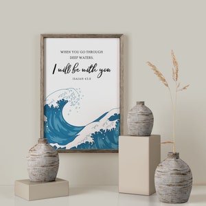 K&ouml;nnte beinhalten: Ein gerahmter Druck mit einem blauen Wellendesign und dem Text "WHEN YOU GO THROUGH DEEP WATERS, I will be with you ISAIAH 43:2".