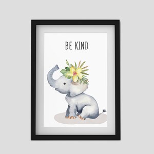 Puede incluir: Una impresi&oacute;n enmarcada con una ilustraci&oacute;n de acuarela de un elefante gris con una corona de flores amarillas. El texto "BE KIND" est&aacute; impreso sobre el elefante.