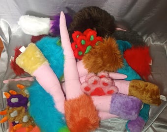May include: A collection of colorful furry tails and paws, perfect for costumes or cosplay. The tails are made of soft, plush fabric and come in a variety of colors, including pink, blue, green, orange, and purple. The paws are also made of soft, plush fabric and come in a variety of colors, including red, green, and brown.