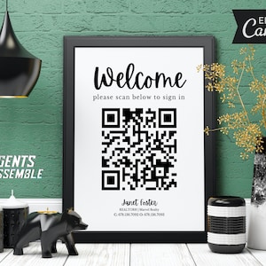 May include: A black and white sign with the text "Welcome" and "please scan below to sign in". A black and white QR code is below the text. The sign also includes the text "Janet Foster, REALTORS | Marvel Realty, C. 678.336.7092 O. 678.136.7053".