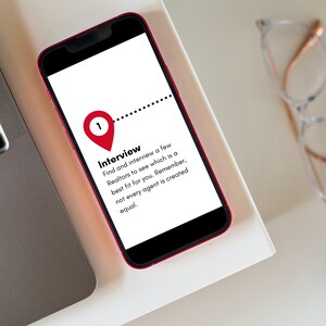May include: A red smartphone with a white screen displaying a numbered list of steps for interviewing real estate agents. The text on the screen reads "Interview: Find and interview a few Realtors to see which is a best fit for you. Remember, not every agent is created equal."