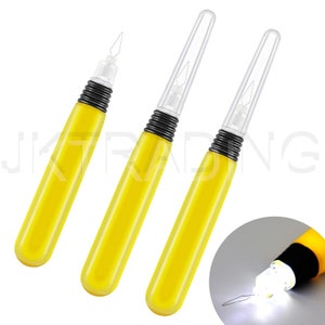May include: Three yellow handled tools with clear plastic tips and black accents. The tools have a needle-like tip and are used for sewing or crafting.