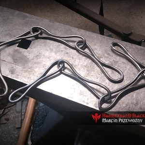 May include: A metal chain link made of multiple loops, crafted by Hammerhand Blacksmith, Marcin Przewozny.