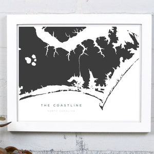 May include: A black and white print of the North Carolina coastline, framed in white. The print reads "The Coastline, North Carolina".