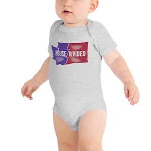May include: A grey baby onesie with a graphic of the state of Washington split in half, one side blue and the other red. The text "HOUSE DIVIDED" is printed on the graphic.