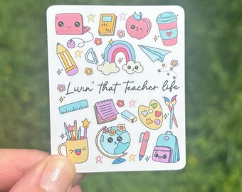 May include: A white sticker with a colorful design featuring various school supplies, including a laptop, pencil, ruler, paintbrush, and a globe. The text "Livin' that teacher life" is written in black cursive font.