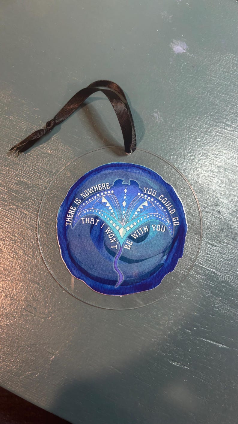 May include: A blue and purple glass ornament with a white stingray design and the text "There is nowhere that I won't be with you. You could go"