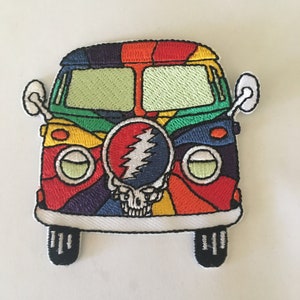 May include: A colorful embroidered patch of a psychedelic van with a Grateful Dead skull and lightning bolt logo on the front.