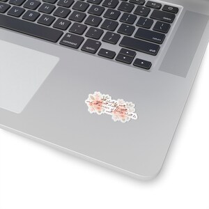 May include: A sticker with a floral design and the text "All shall be well, and all shall be well, and all manner of things shall be well."