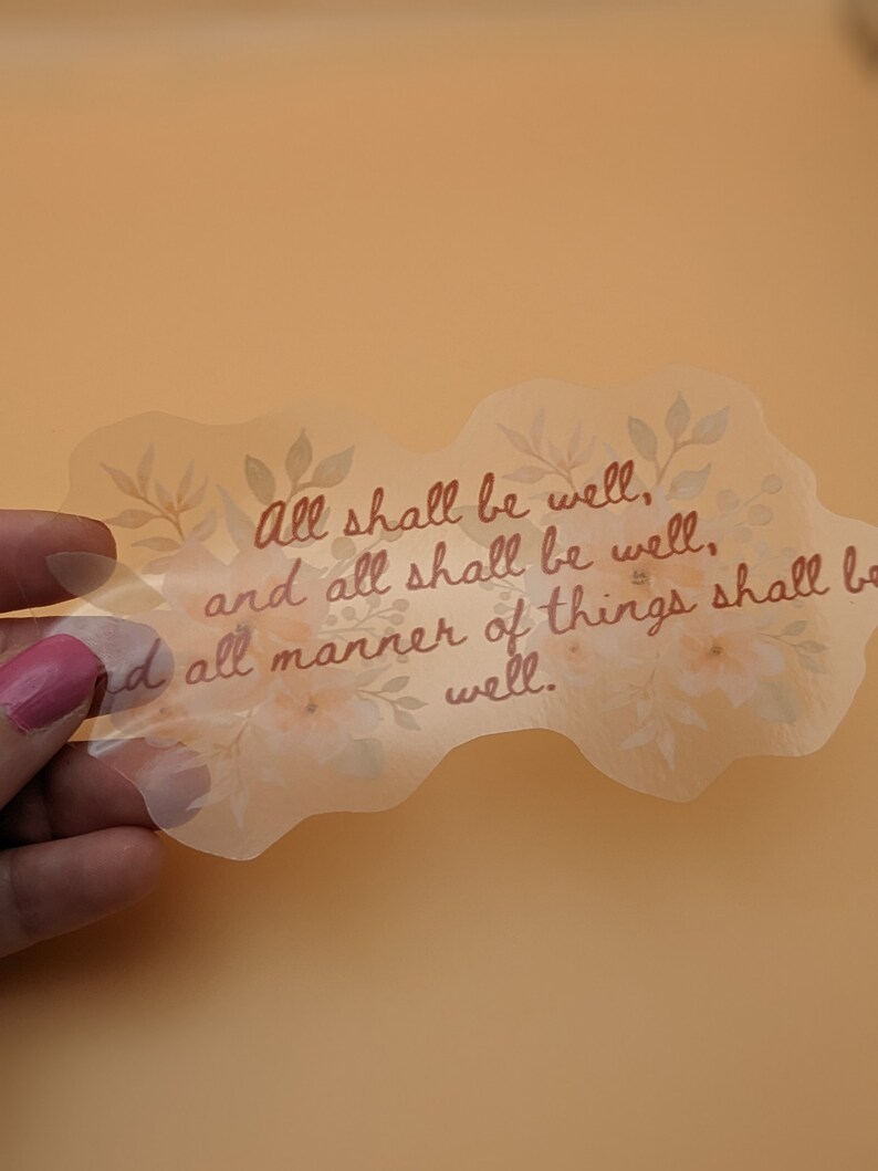 May include: A clear sticker with a floral design and the text "All shall be well, and all shall be well. And all manner of things shall be well."