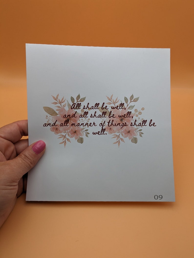 May include: A white card with a floral design and the text "All shall be well, and all shall be well, and all manner of things shall be well." The card has the number 09 printed in the bottom right corner.