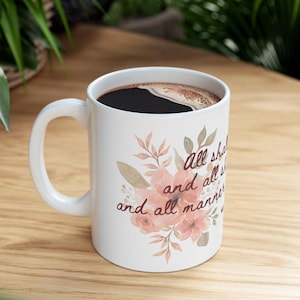 以下が含まれることがあります： 花柄の白いセラミック製のコーヒーカップで、"all shall be well and all shall be well and all manner of things shall be well"というテキストが書かれています。