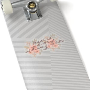 May include: A skateboard deck with a gray and white striped pattern. The deck features a floral design with the text "All shall be well, and all shall be well, and all manner of things shall be well."