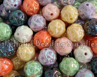 May include: A large assortment of iridescent glass beads with a floral design. The beads are various shades of pink, green, orange, purple, and brown.