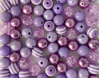 May include: A collection of lavender beads in various styles. Some are solid, others have white stripes, iridescent finishes, or a textured, crystal-like appearance. The beads are for jewelry making and crafting.