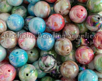 May include: A large assortment of iridescent round beads in various colors, including pink, blue, green, and brown. The beads have a white swirl pattern and a glossy finish.