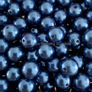May include: Close-up of a collection of navy blue, round beads. The beads have a glossy, reflective surface and are scattered across the frame. The text "Gladiolus Beading Supplies" is visible at the bottom.