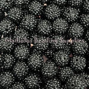 May include: Close-up of a pile of black rhinestone beads. The beads are round and covered in small, sparkling rhinestones. The text "Gladiolus Beading Supplies" is visible in the image.