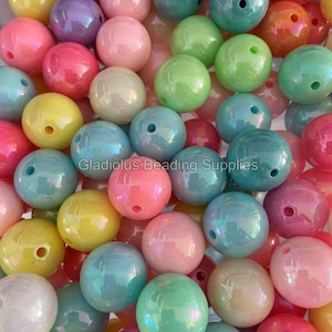 May include: A large assortment of iridescent pastel-colored round beads. The beads are made of plastic and have a smooth, glossy finish.  The beads are perfect for making jewelry, crafts, and other projects.