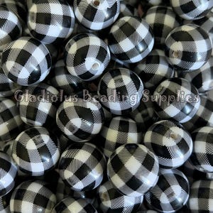 May include: A pile of round beads with a black and white buffalo plaid pattern. The beads have a hole drilled through the center. The text "Gladiolus Beading Supplies" is visible on the bottom of the image.