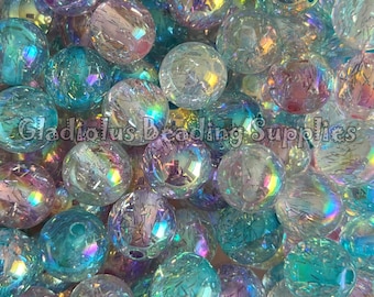 May include: A collection of iridescent, clear glass beads with a crackled texture. The beads are round and vary in size, reflecting a rainbow of colors. The text "Gladiolus Beading Supplies" is visible.