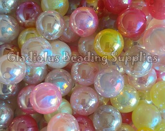 May include: A close-up of a pile of iridescent, spherical beads in shades of pink, yellow, and clear. The beads have a shiny surface and reflect light. The text "Gladiolus Beading Supplies" is visible.