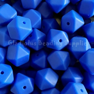 May include: A close-up of a pile of bright blue silicone beads. The beads are shaped like a diamond with a hole in the center. The beads are perfect for making jewelry or other crafts.